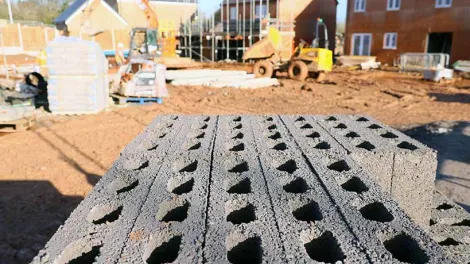 Bloques de hormigón en obra de edificación, representación del análisis de materiales y la medición de la huella de carbono en la construcción sostenible.
