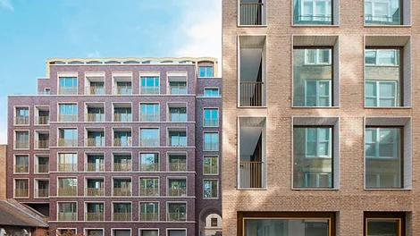 Fachada de un edificio residencial moderno de ladrillo visto, ilustrando la importancia de la conservación y la rehabilitación técnica para asegurar la seguridad y durabilidad de las estructuras tras una ITE.