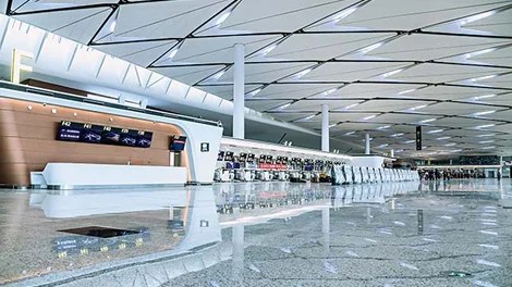 Pavimento continuo pulido en terminal de aeropuerto con superficie nivelada y acabado brillante de gran formato