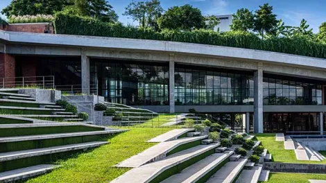 Edificio autosuficiente con cubierta vegetal y diseño bioclimático, ejemplo de arquitectura sostenible y eficiencia energética en edificación contemporánea.