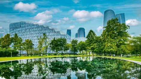 Ciudad inteligente y ecológica con infraestructuras de bajas emisiones de carbono, destacando zonas verdes urbanas y arquitectura de vanguardia diseñada para la eficiencia energética