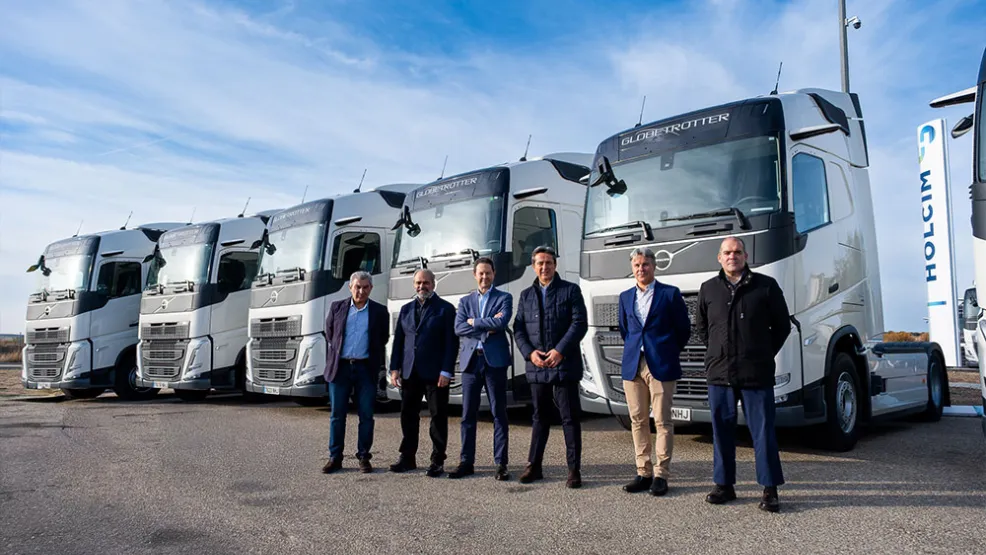 equipo participante en adquisición de una flota propia de 30 camiones Volvo delante de camiones