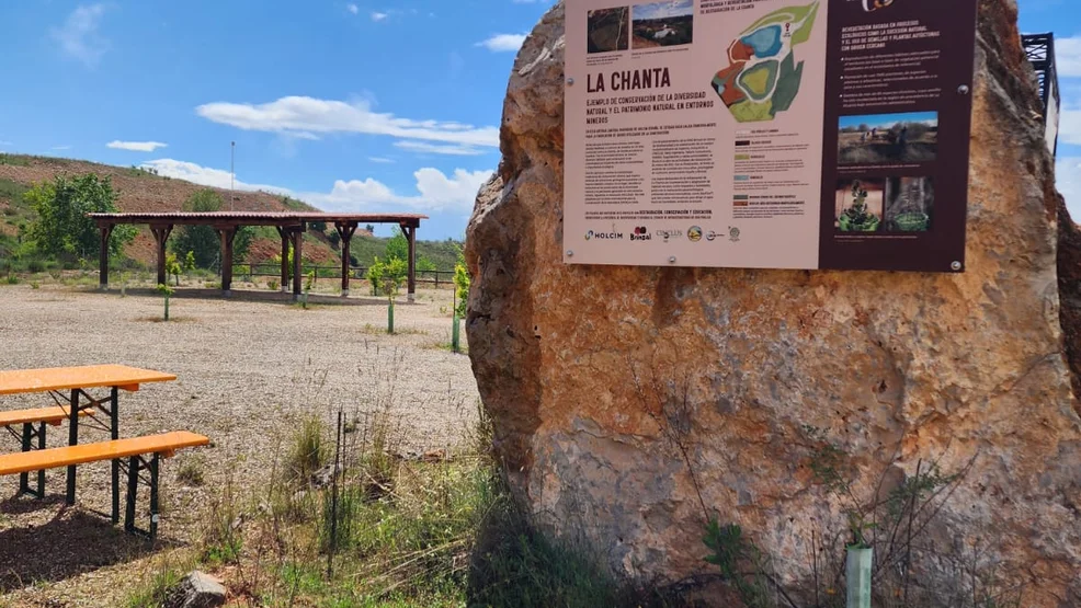 Panel informativo instalado sobre una gran roca que muestra el mapa de restauración ecológica, las lagunas y los procesos de sucesión natural en la antigua cantera de La Chanta.