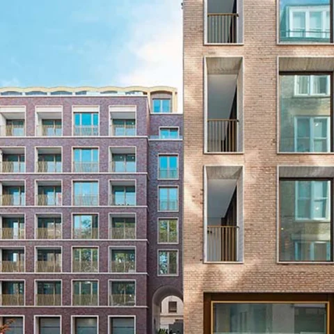 Fachada de un edificio residencial moderno de ladrillo visto, ilustrando la importancia de la conservación y la rehabilitación técnica para asegurar la seguridad y durabilidad de las estructuras tras una ITE.