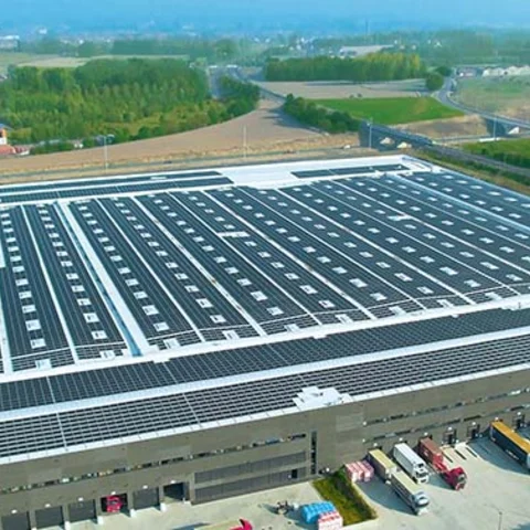 Vista aérea de nave industrial rehabilitada: nueva cubierta con placas solares como eje de eficiencia energética y sostenibilidad.