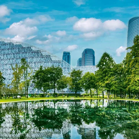 Ciudad inteligente y ecológica con infraestructuras de bajas emisiones de carbono, destacando zonas verdes urbanas y arquitectura de vanguardia diseñada para la eficiencia energética